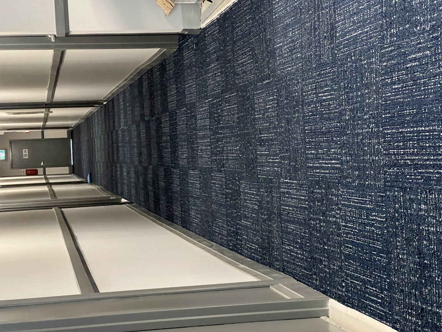 Apartment corridor: worn carpet replaced with fresh, durable carpet — After